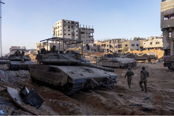 Un grupo de soldados se encuentra cerca de tanques en una zona desierta.