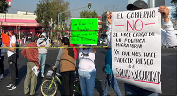 Un grupo de personas con carteles en una calle.