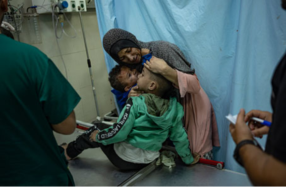 Una mujer abraza a un niño en un hospital.