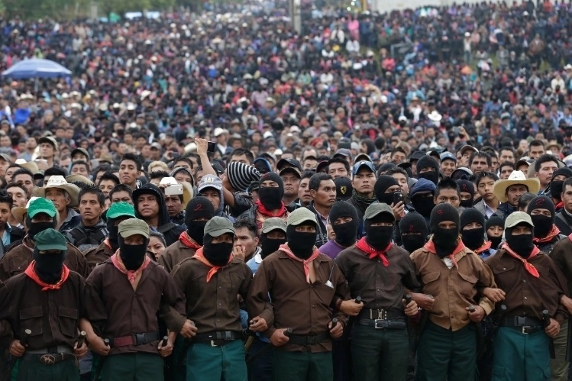 Una gran multitud de personas con máscaras y sombreros negros.