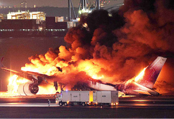 Un avión se incendia en la pista por la noche.