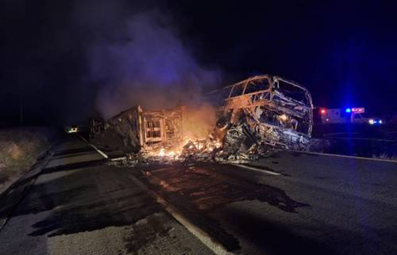 Un autobús se incendia al costado de la carretera.