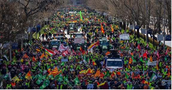 Un gran grupo de personas marchando por una calle.