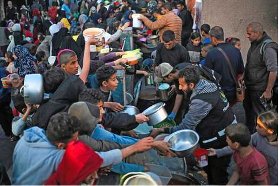 Multitud de personas se reunieron para la distribución de alimentos en un concurrido escenario al aire libre.