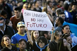 Un manifestante sostiene un cartel que dice "sin universidad no hay futuro" entre la multitud durante una manifestación.