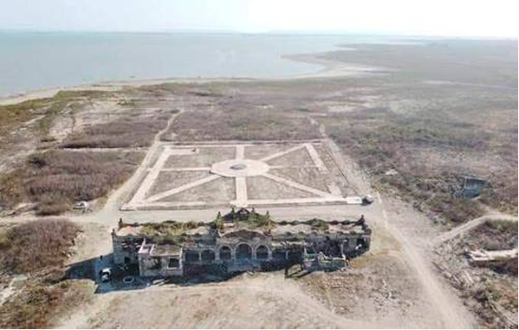 Vista aérea de una ruinosa fortaleza en forma de estrella en una llanura costera, que muestra un diseño geométrico claro y restos de murallas.