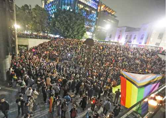 Una gran multitud de personas se reunió en una ciudad por la noche.