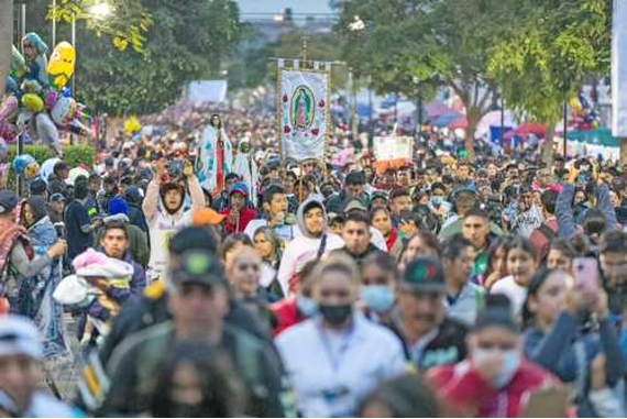 Una multitud de personas caminando por una calle de noche.