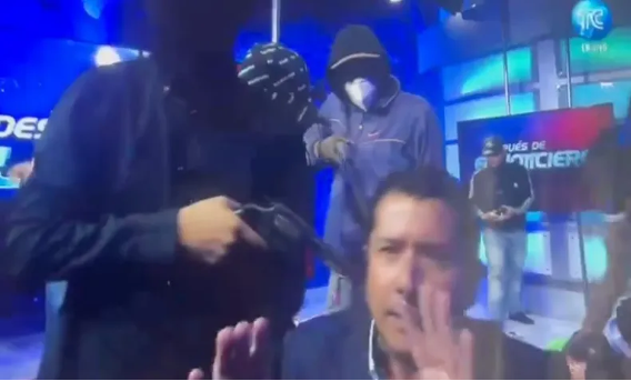 Un hombre con capucha sostiene un arma.