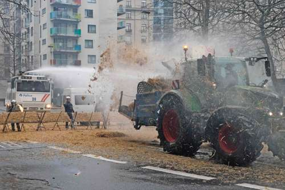 Un tractor rocía agua en una calle de la ciudad.