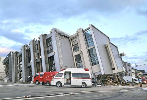 Dos ambulancias están estacionadas frente a un edificio que se derrumbó.