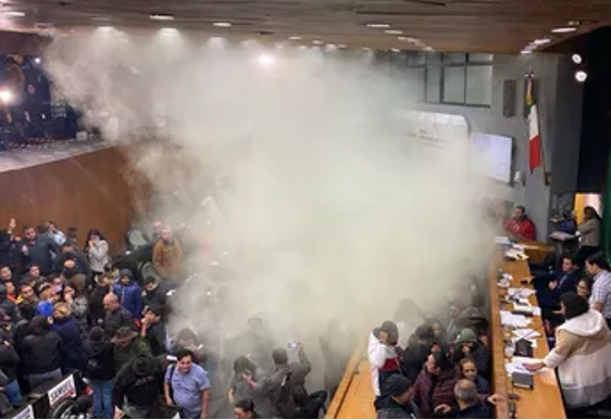 Un grupo de personas paradas en una habitación de la que sale humo.