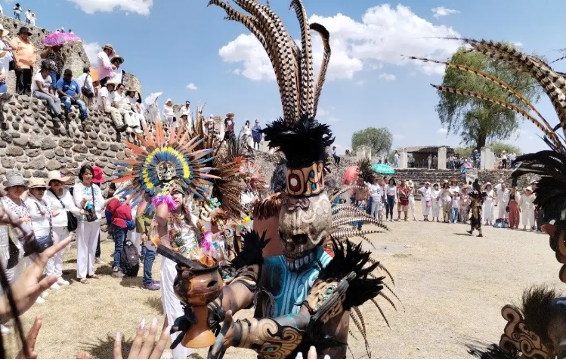 Coloridos bailarines tradicionales actuando en un evento cultural al aire libre.