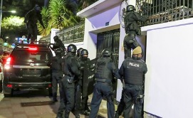 Agentes de policía con equipo táctico escalando una pared blanca durante una operación nocturna.