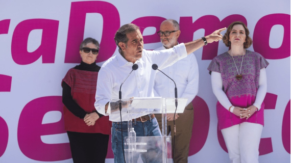 Un grupo de personas paradas frente a un podio.