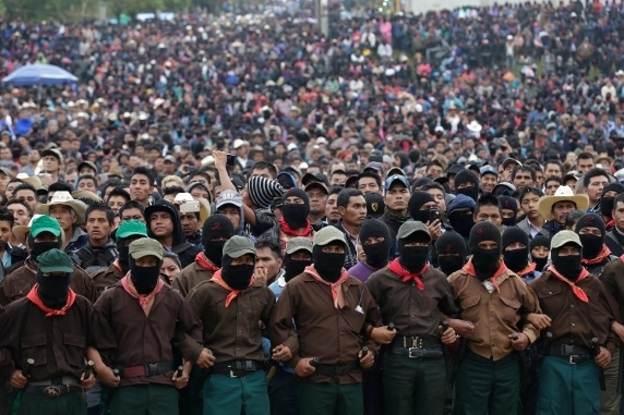 Una gran multitud de personas con mÃ¡scaras y sombreros negros.