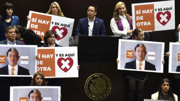 Un grupo de personas sosteniendo carteles frente a un edificio.