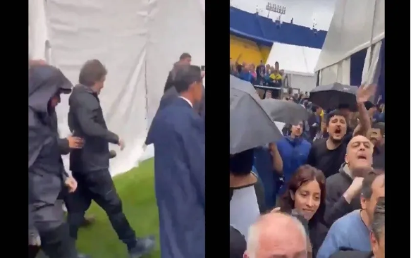 Un grupo de personas sostiene paraguas en un estadio.