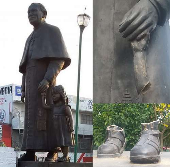 Una estatua de un hombre sosteniendo a un niño y un par de zapatos.
