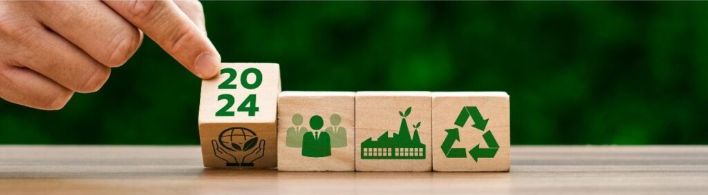Una mano gira un bloque de madera para revelar "2024", junto a bloques con Ã­conos que representan la comunidad, las prÃ¡cticas sostenibles y el reciclaje.