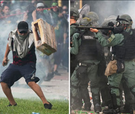 Un manifestante con una paleta de madera se enfrenta a una línea de policías armados con equipo antidisturbios.