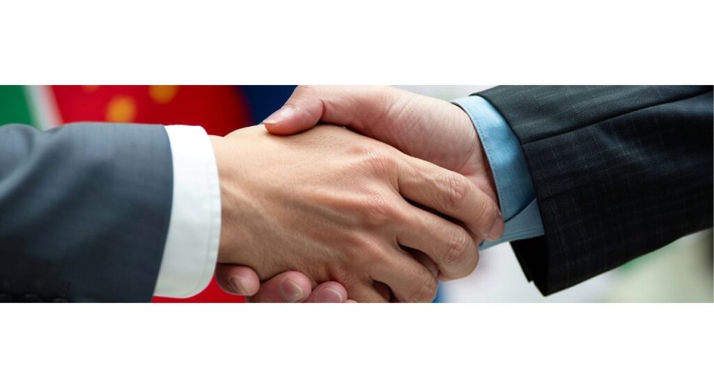 Dos personas de traje se dan la mano, simbolizando un acuerdo o trato comercial, en medio de un contexto de disputas internacionales.