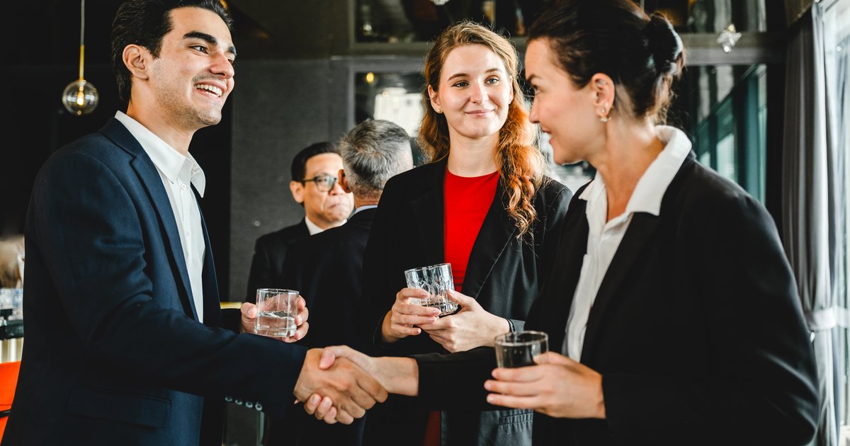 Profesionales saludándose en un evento de networking corporativo